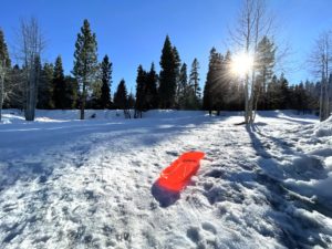 Red sled on sledding hill 
