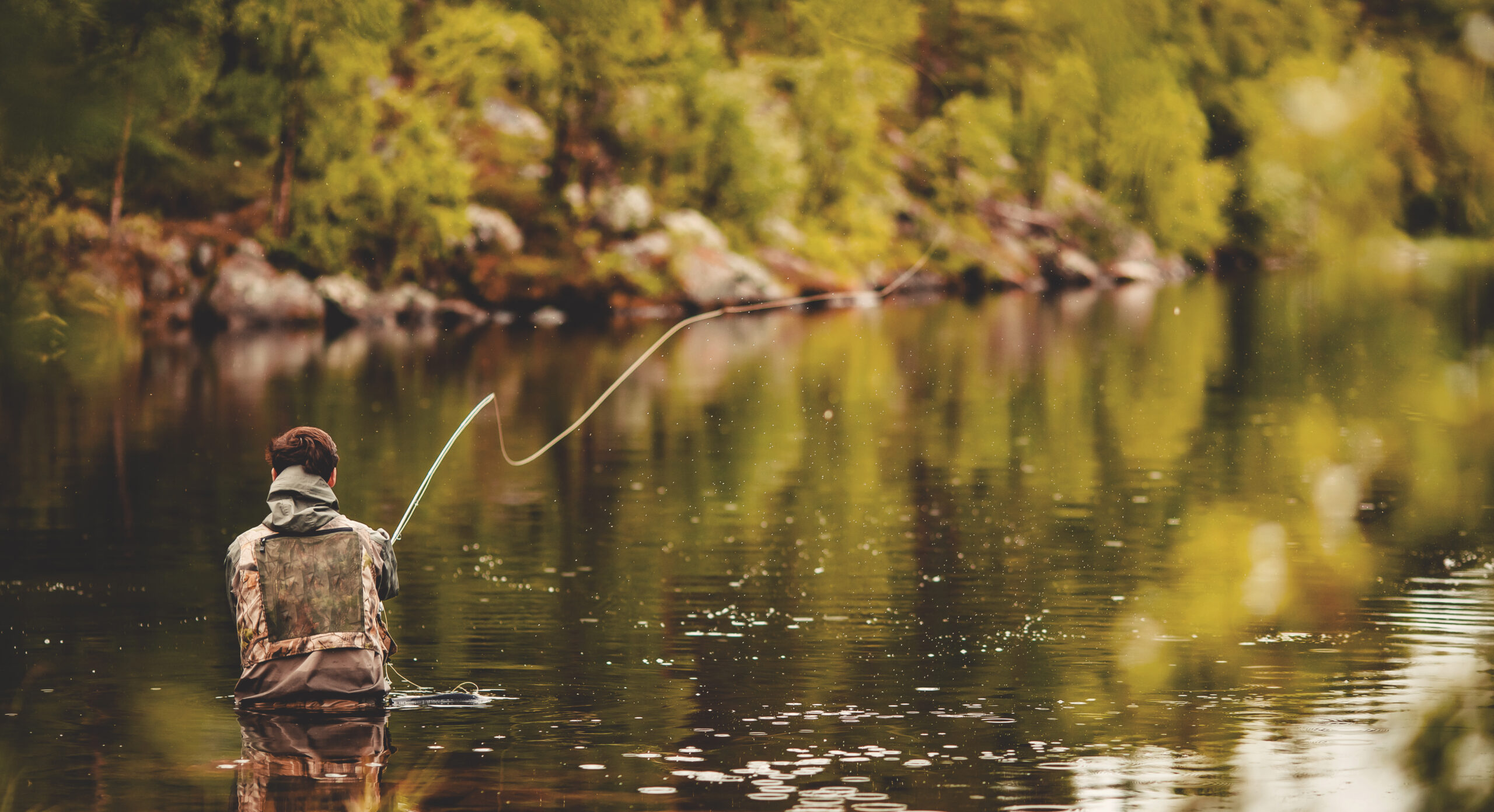 Fisherman using rod fly fishing in river morning sunrise banner