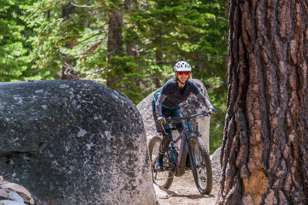 female mountain biker going through trees