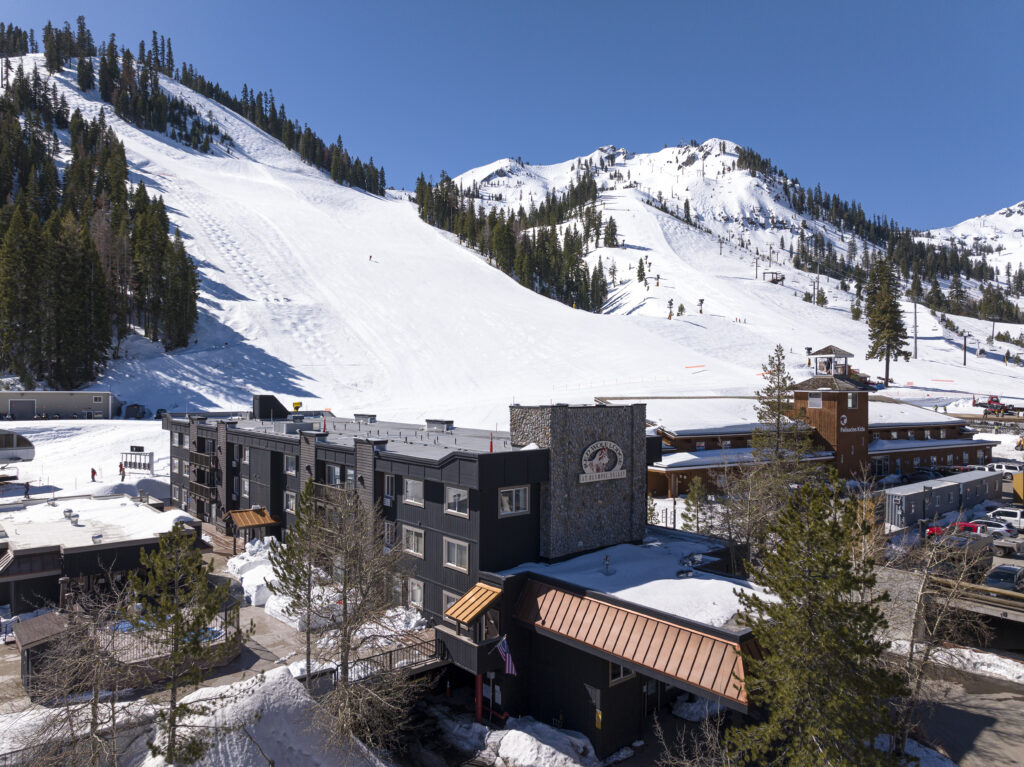 brown building in front of snowy mountain